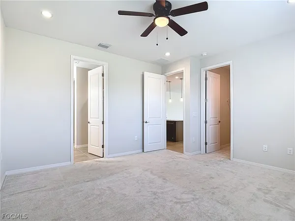 an empty room with closet and windows