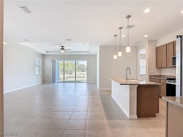 a large kitchen with kitchen island granite countertop a large counter top a sink stainless steel appliances and cabinets