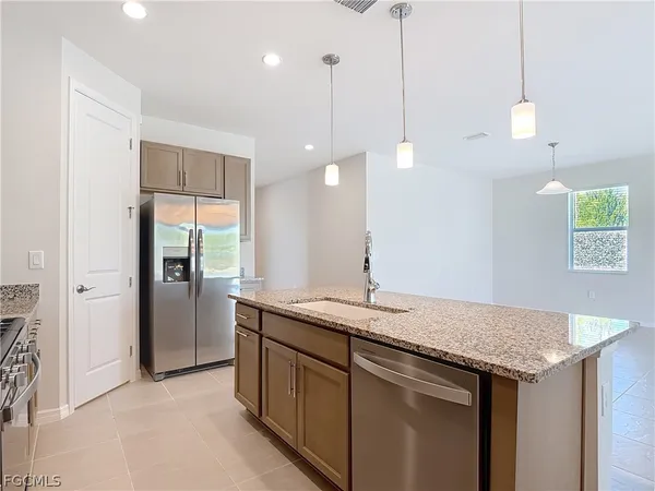 a kitchen with a sink a counter space and a refrigerator