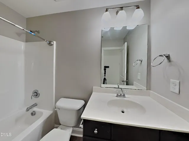a bathroom with a sink mirror toilet and bathtub