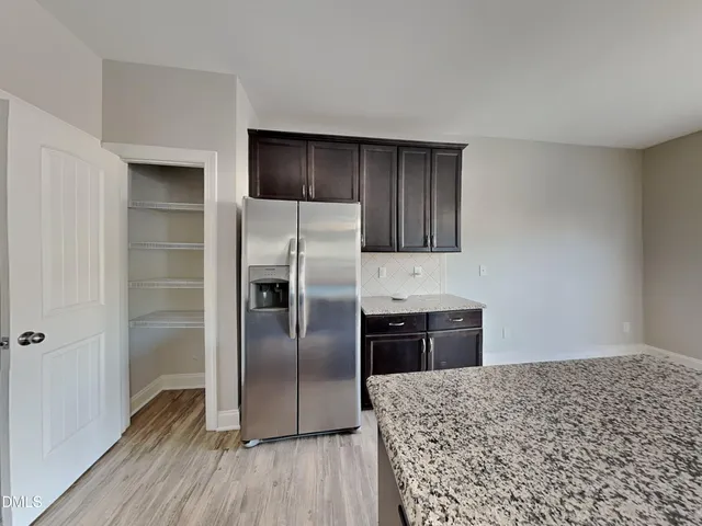 a kitchen with a refrigerator and a stove top oven