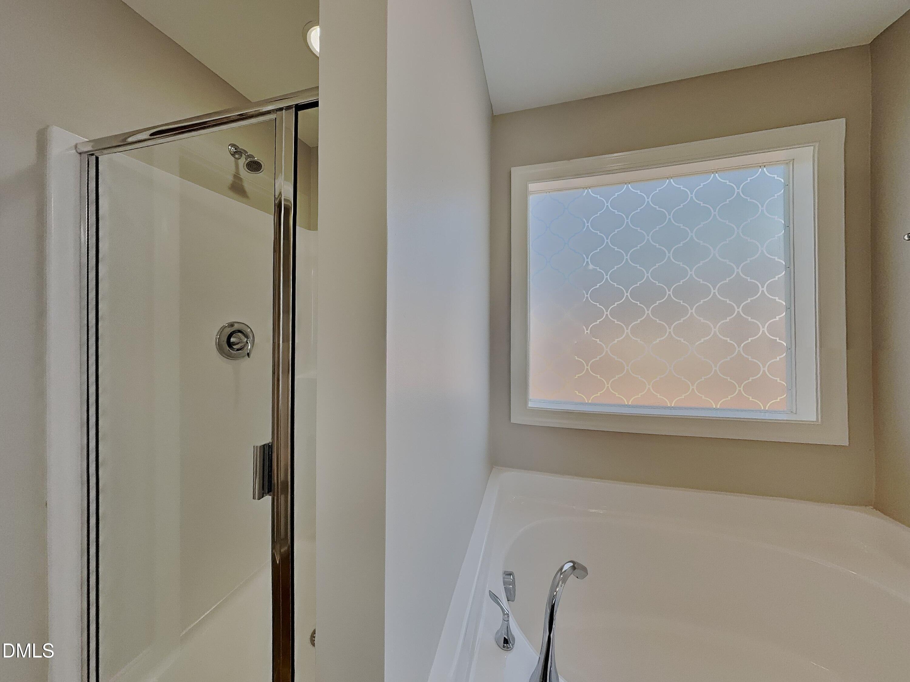 93 Jonalker Court Clayton, NC 27520 - Photo 8 of 17 a bathroom with a shower and a window