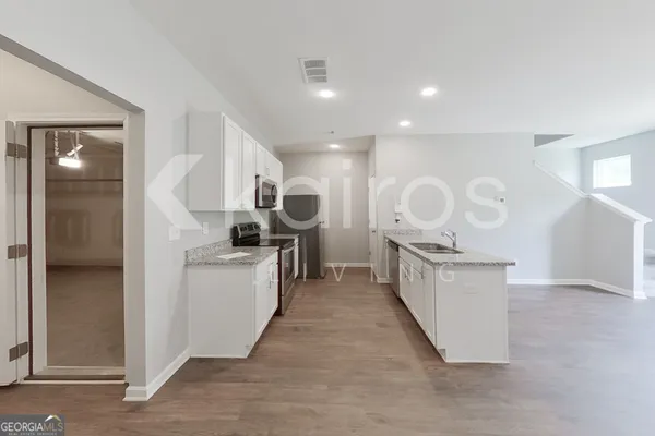 a kitchen with granite countertop a sink and a stove top oven