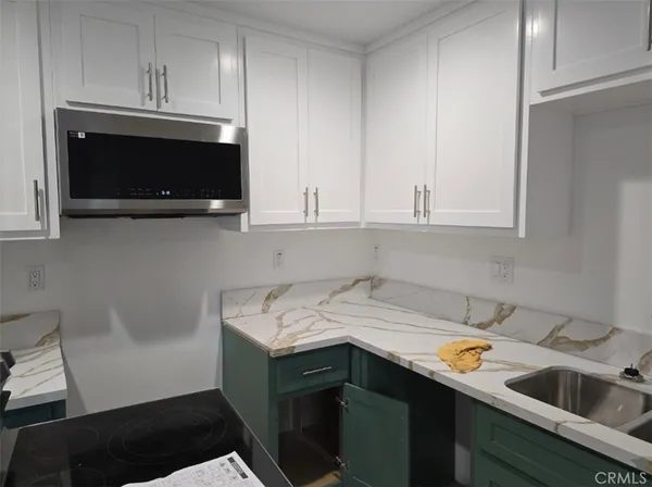a kitchen with a sink dishwasher stove and cabinets