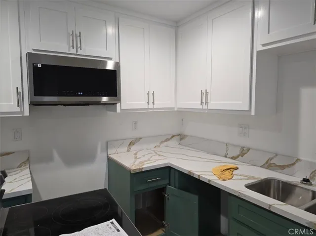 a kitchen with a sink dishwasher stove and cabinets