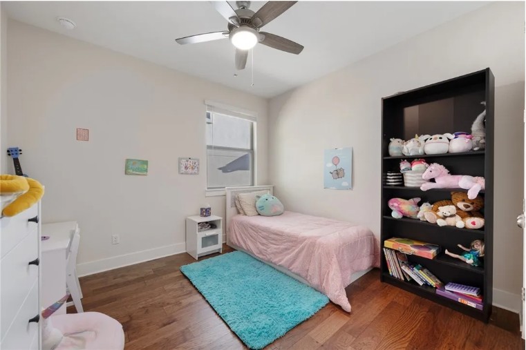 344 Pisa Lane Georgetown, TX 78628 - Photo 22 of 39 Rich wood flooring anchors this versatile bedroom complete with a tall built-in bookcase.