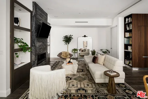 a living room with furniture a flat screen tv and a fireplace