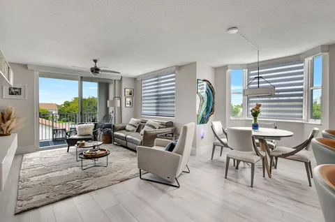 a living room with furniture a flat screen tv and a large window
