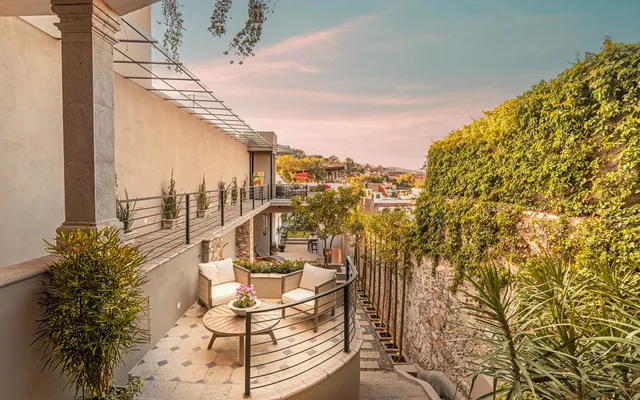 a view of a balcony with table and chairs and iron fence
