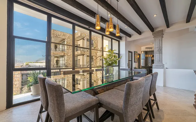 a dining room with furniture large windows and wooden floor