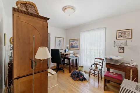 a view of a workspace with furniture and a window