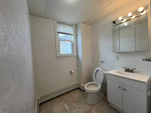 a bathroom with a toilet a sink and mirror