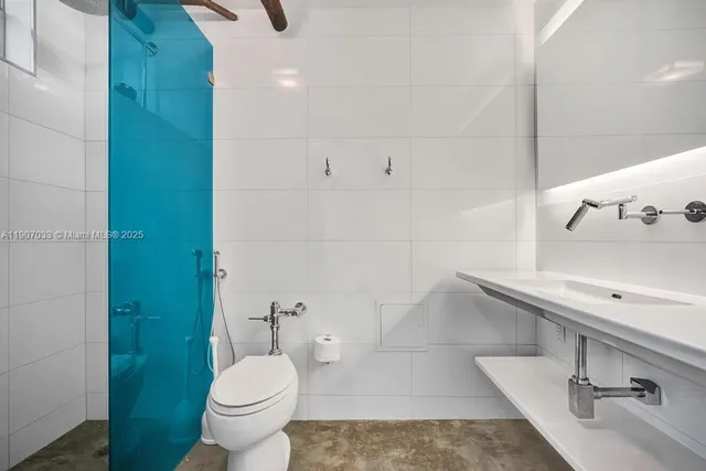 a bathroom with a sink vanity mirror and toilet