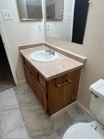 a bathroom with a granite countertop sink and a mirror