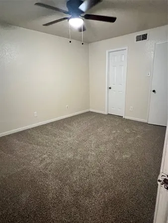 an empty room with a ceiling fan and closet