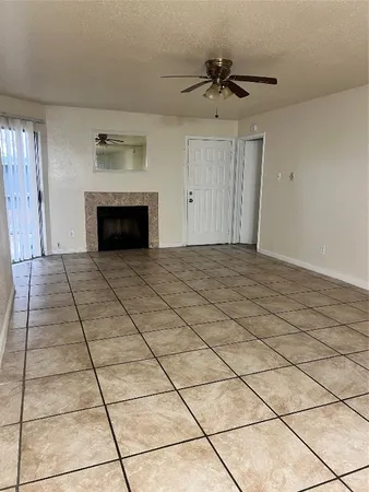 a view of empty room with cabinet and fan