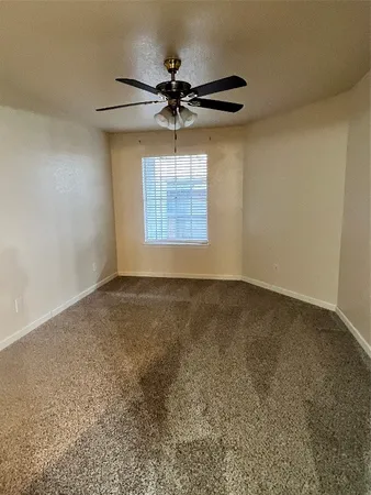 en empty room with windows and fan