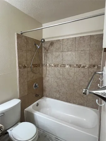 a white toilet and tub sitting next to a bathroom sink