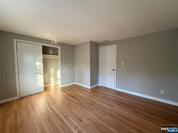 a view of an empty room with closet and a window