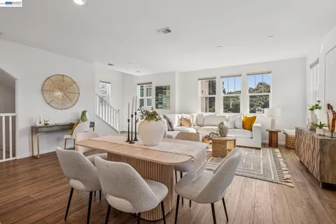 a living room with furniture dining table and a large window
