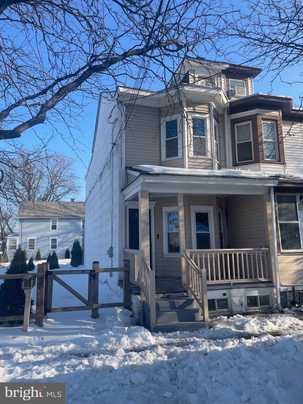 a view of a house with a yard and wooden fence