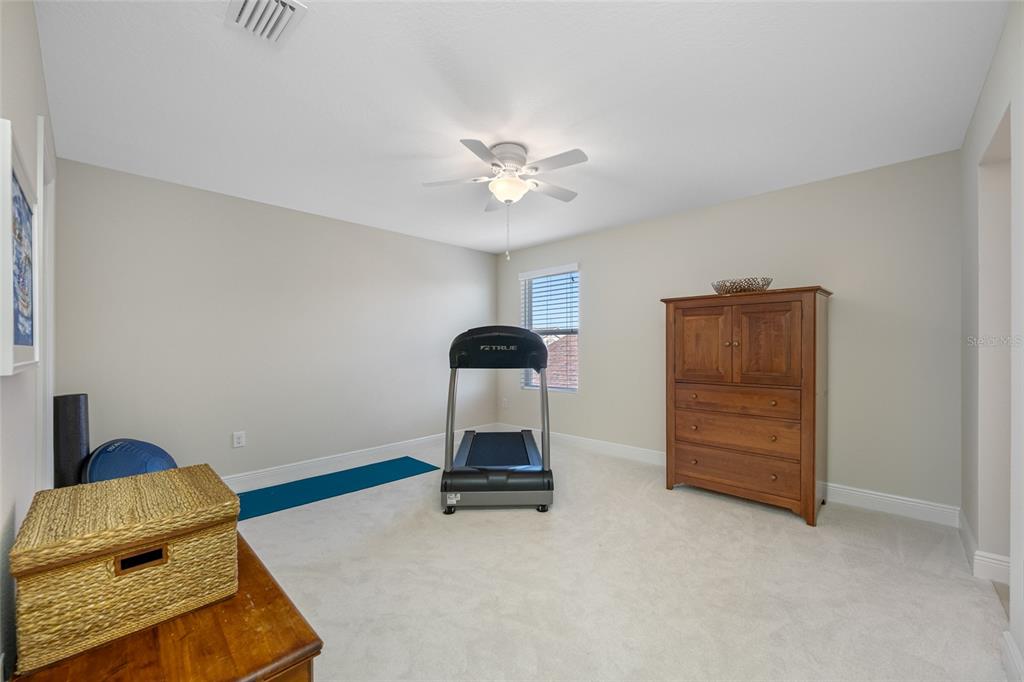 19709 Long Lake Ranch Boulevard Lutz, FL 33558 - Photo 41 of 59 a bedroom with a bed and a ceiling fan