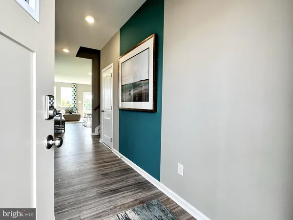a view of a hallway with wooden floor and a living room