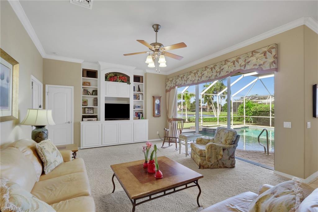 11079 Phoenix Way Naples, FL 34119 - Photo 5 of 30 Carpeted living area with a sunroom, ornamental molding, ceiling fan, and built in features