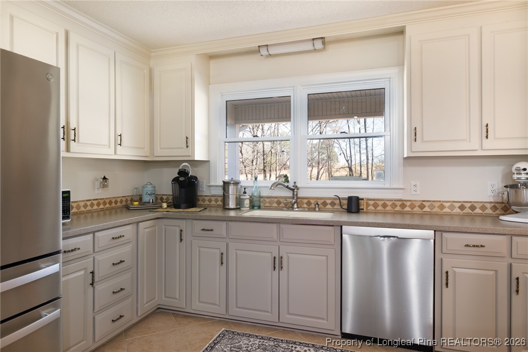 2574 Norrington Road Lillington, NC 27546 - Photo 12 of 50 a kitchen with white cabinets and white appliances