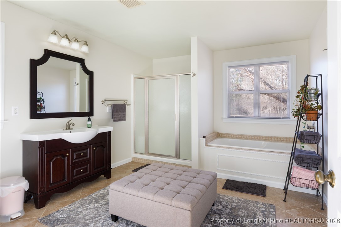 2574 Norrington Road Lillington, NC 27546 - Photo 25 of 50 a bathroom with a tub sink and mirror