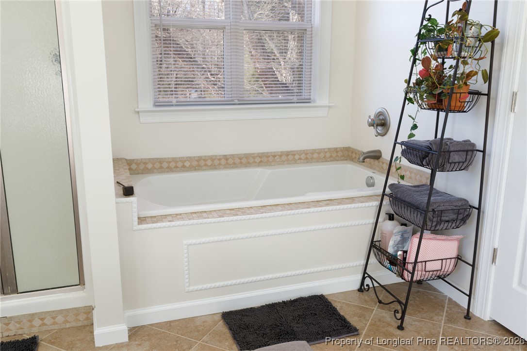 2574 Norrington Road Lillington, NC 27546 - Photo 27 of 50 a bathroom with a bathtub and next to a window
