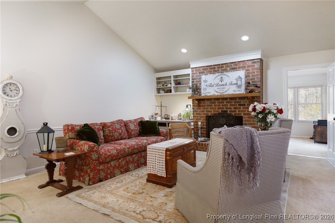 2574 Norrington Road Lillington, NC 27546 - Photo 6 of 50 a living room with furniture a fireplace and a flat screen tv