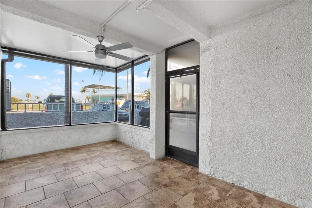 337 Rex Place, Unit A Madeira Beach, FL 33708 - Photo 6 of 48 an empty room with chandelier fan and windows