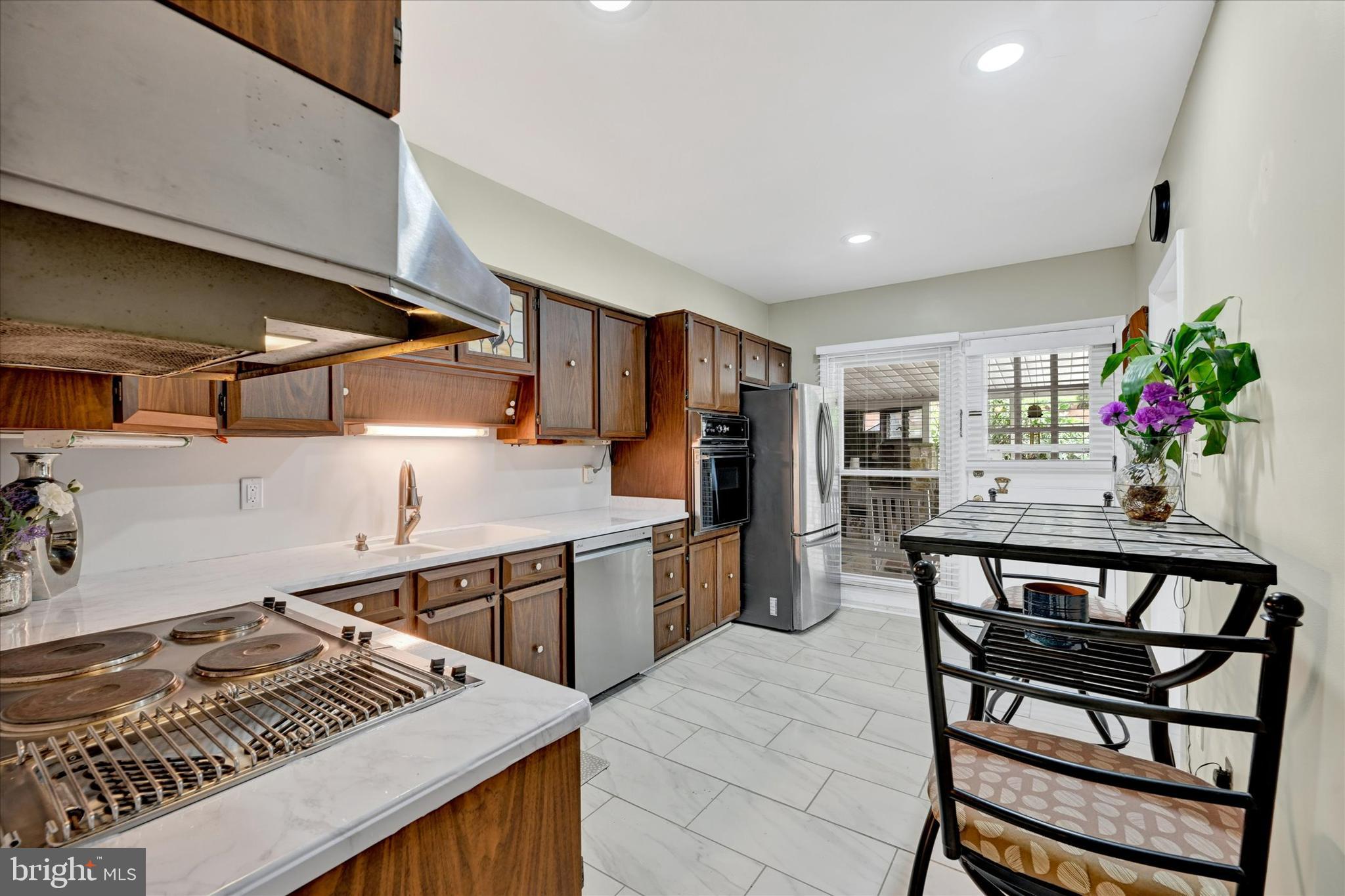 6708 Selkirk Road Baltimore, MD 21239 - Photo 13 of 30 a kitchen with stainless steel appliances granite countertop a stove a sink dishwasher and cabinets