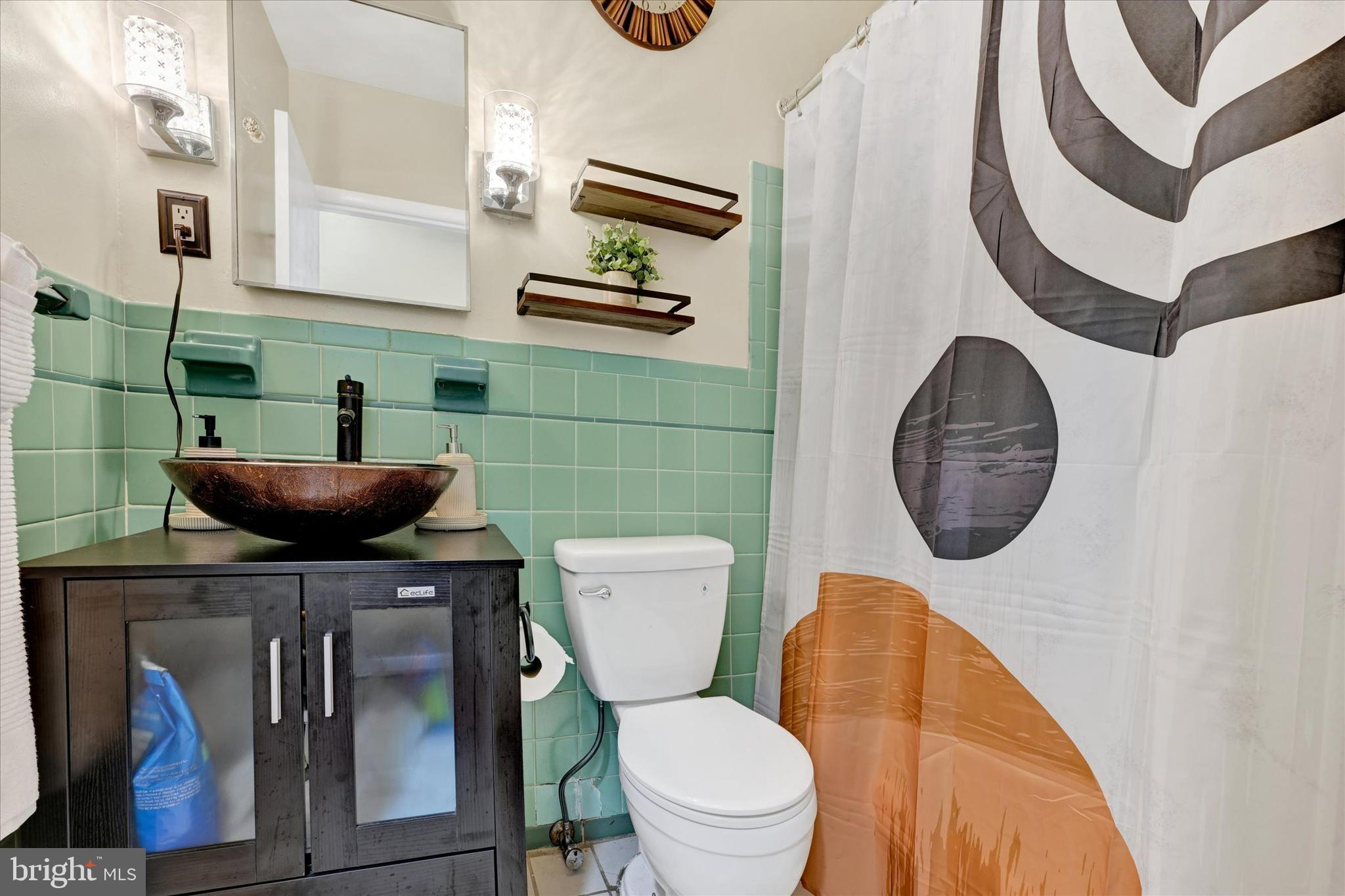 6708 Selkirk Road Baltimore, MD 21239 - Photo 16 of 30 a bathroom with a toilet a sink and mirror