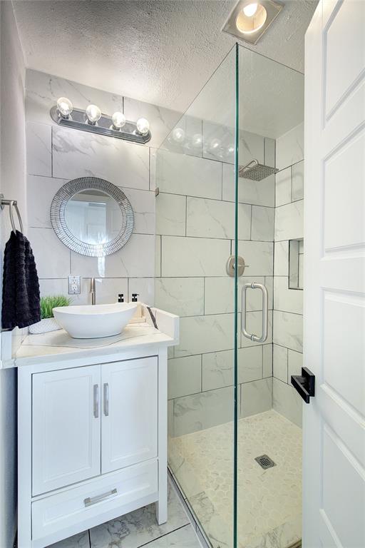 504 Summit Circle Heath, TX 75032 - Photo 10 of 39 a bathroom with a sink vanity and shower