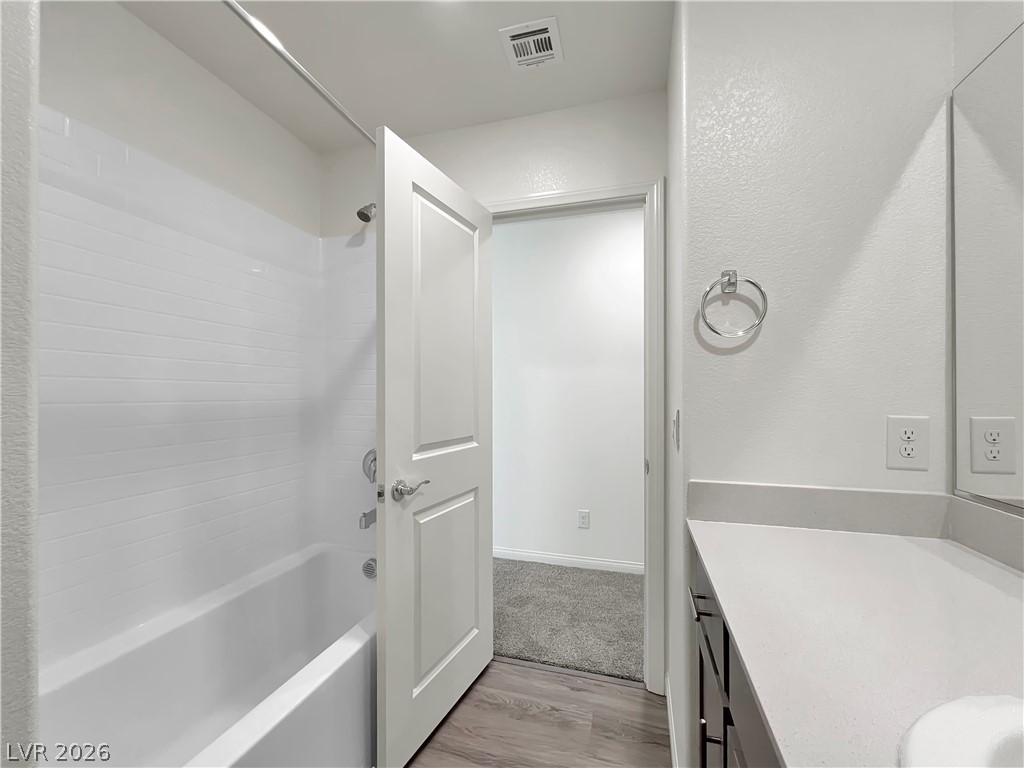 9984 Indigo Cliffs Street Las Vegas, NV 89141 - Photo 25 of 31 Bathroom with vanity, wood finished floors, washtub / shower combination, and visible vents