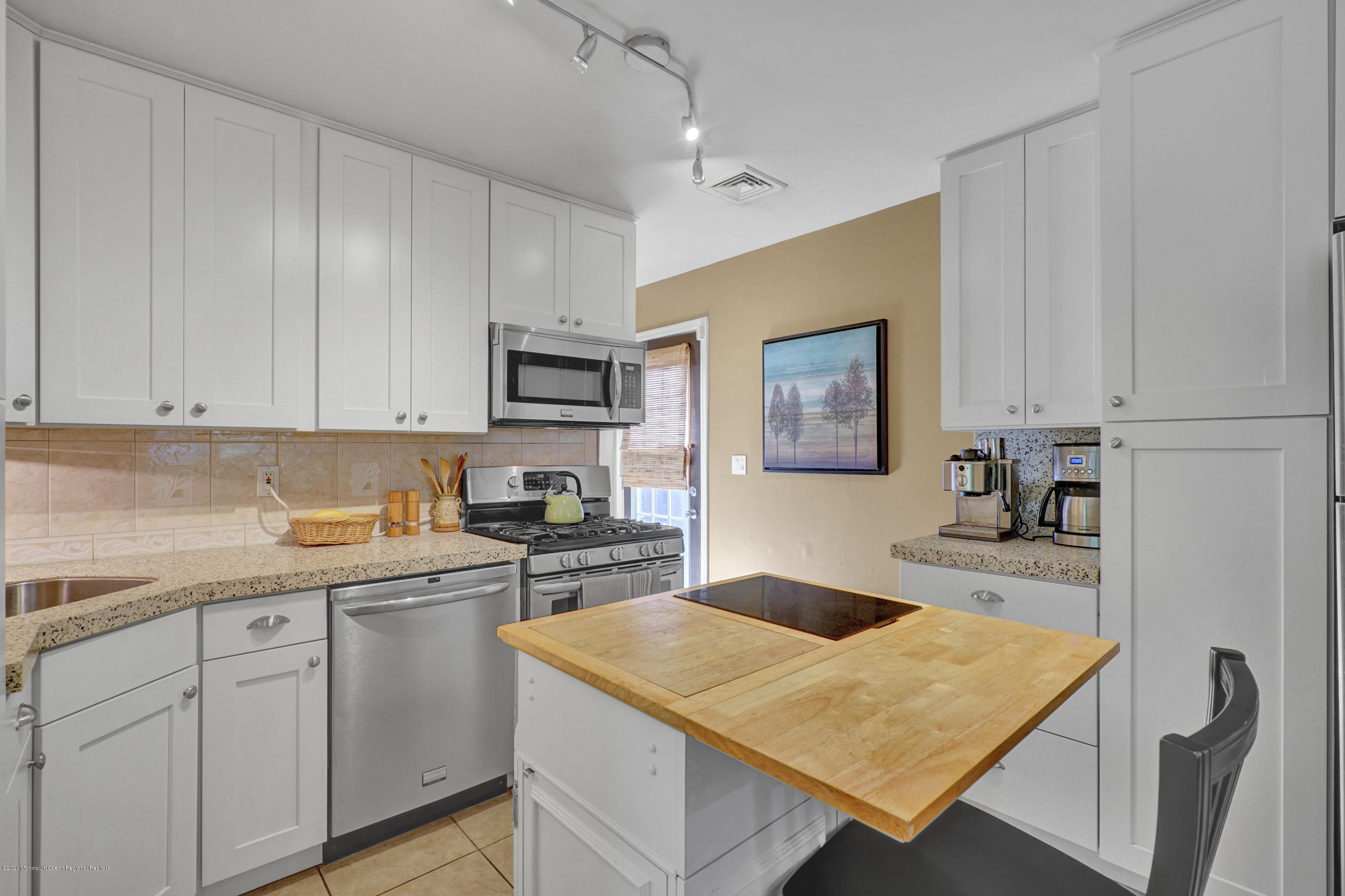 25 Harbor Road Morganville, NJ 07751 - Photo 23 of 39 a kitchen with a stove a sink a microwave and cabinets