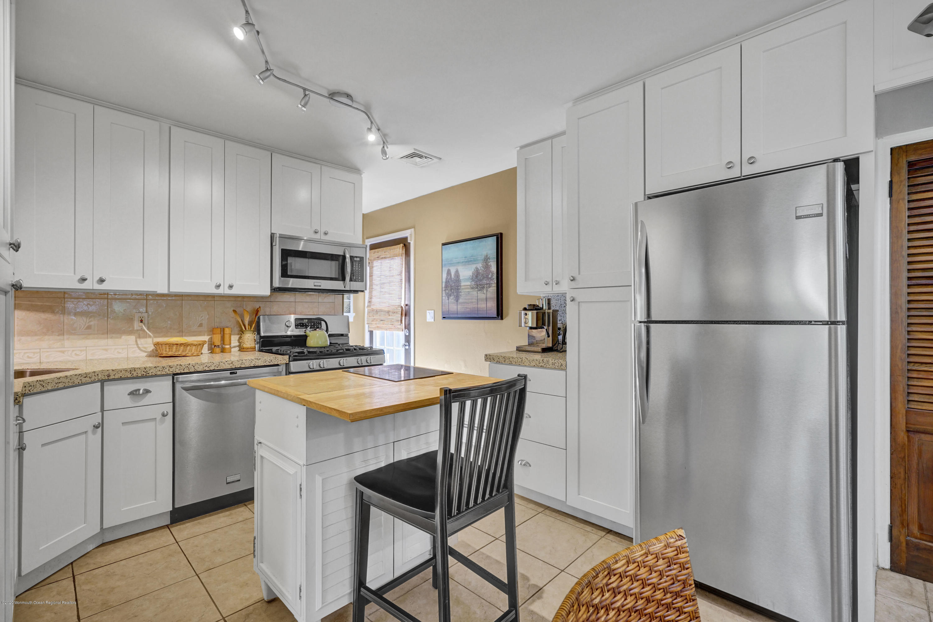 25 Harbor Road Morganville, NJ 07751 - Photo 7 of 39 a kitchen with stainless steel appliances granite countertop a refrigerator a sink dishwasher a stove with white cabinets and wooden floor