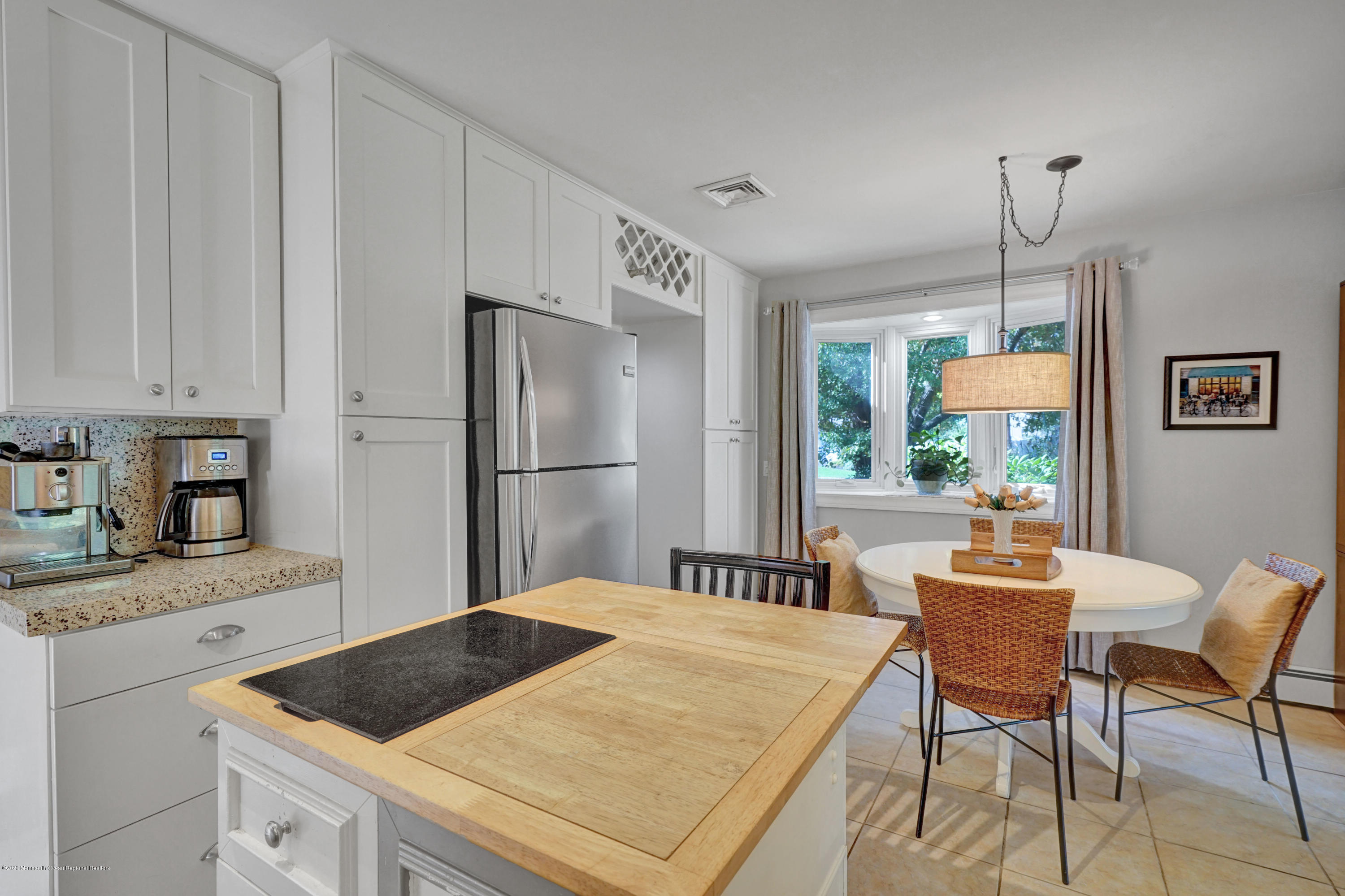 25 Harbor Road Morganville, NJ 07751 - Photo 10 of 39 a kitchen with a refrigerator a table and chairs in it