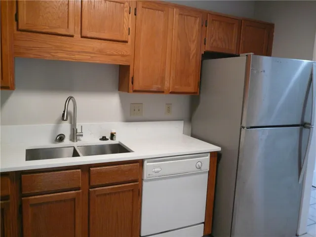 a kitchen with a refrigerator sink and cabinets