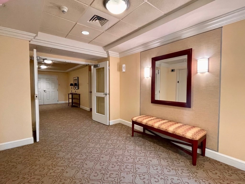 38 Village Road, Unit 208 Middleton, MA 01949 - Photo 3 of 39 a spacious bedroom with a bed and a chandelier