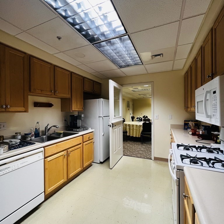 38 Village Road, Unit 208 Middleton, MA 01949 - Photo 33 of 39 a kitchen with stainless steel appliances granite countertop a stove a sink dishwasher and a refrigerator