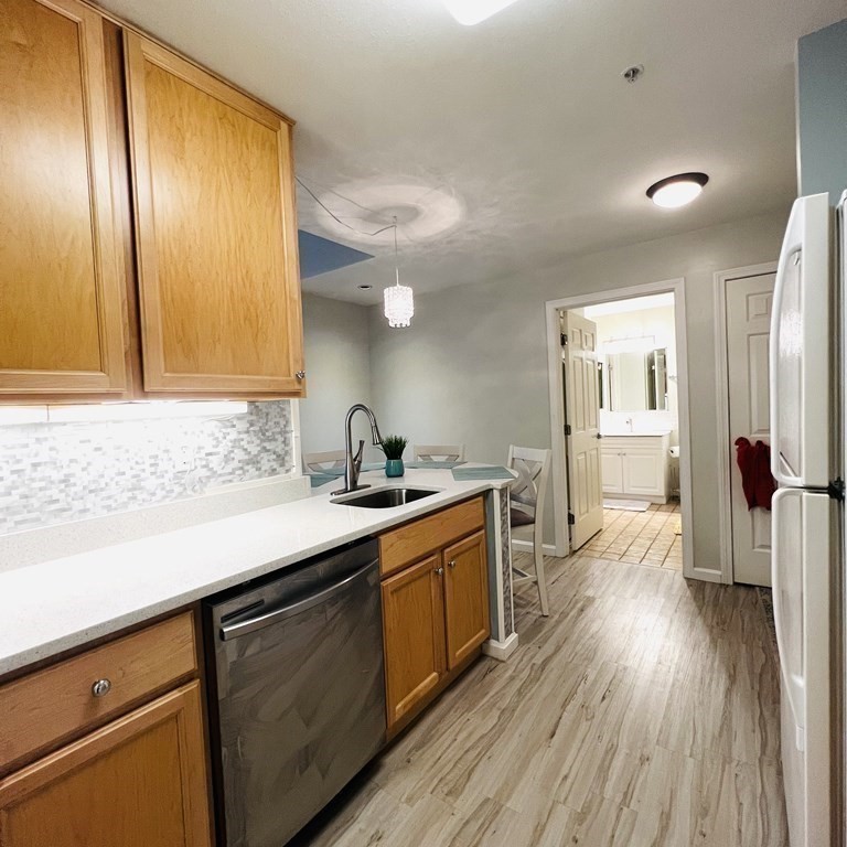38 Village Road, Unit 208 Middleton, MA 01949 - Photo 8 of 39 a kitchen with wooden floors and cabinets