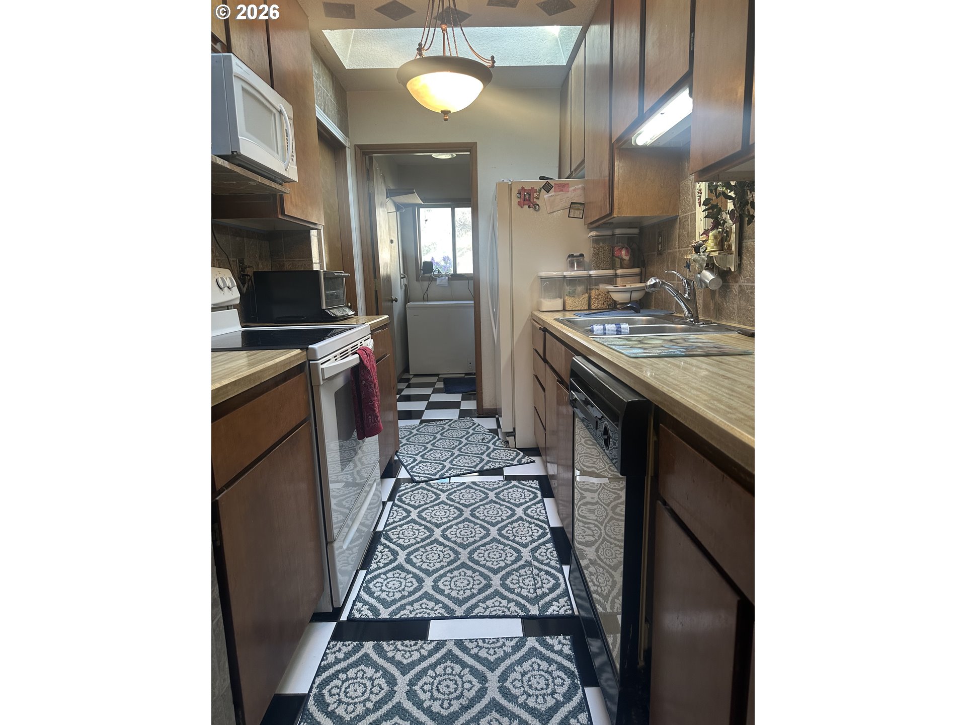 6792 Southeast Juniper Canyon Road Prineville, OR 97754 - Photo 7 of 44 a kitchen with granite countertop a sink stove and cabinets
