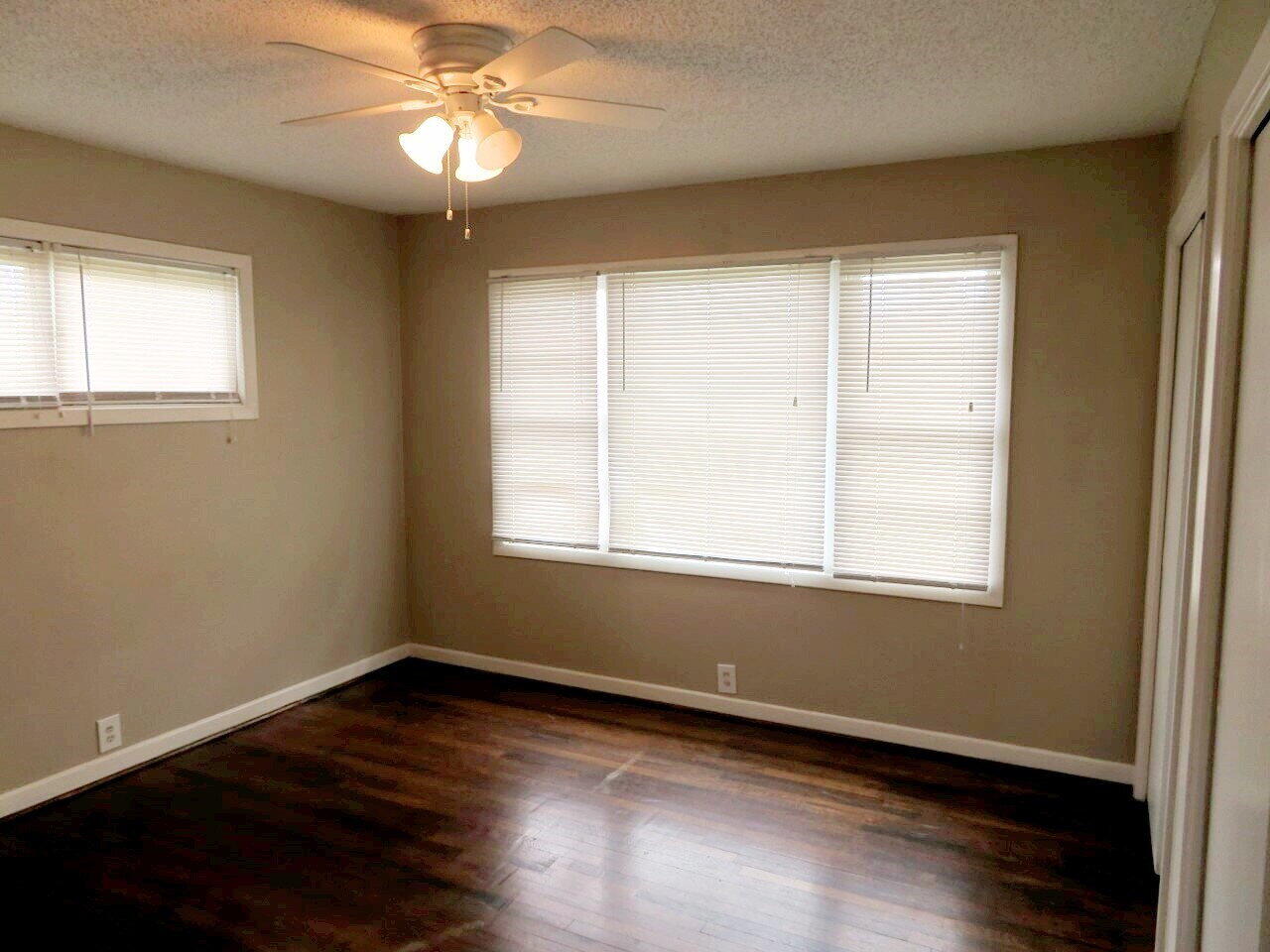 3211 33rd Street Lubbock, TX 79410 - Photo 7 of 7 a view of an empty room with wooden floor and a window