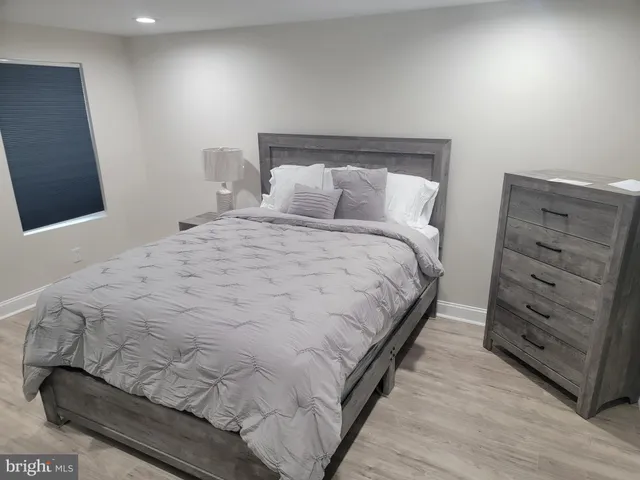 a large bed sitting in a bedroom next to a window