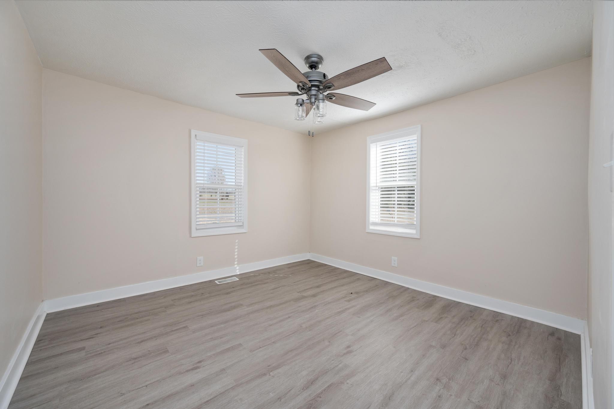 621 Halltown Road Portland, TN 37148 - Photo 14 of 23 an empty room with wooden floor a ceiling fan and windows