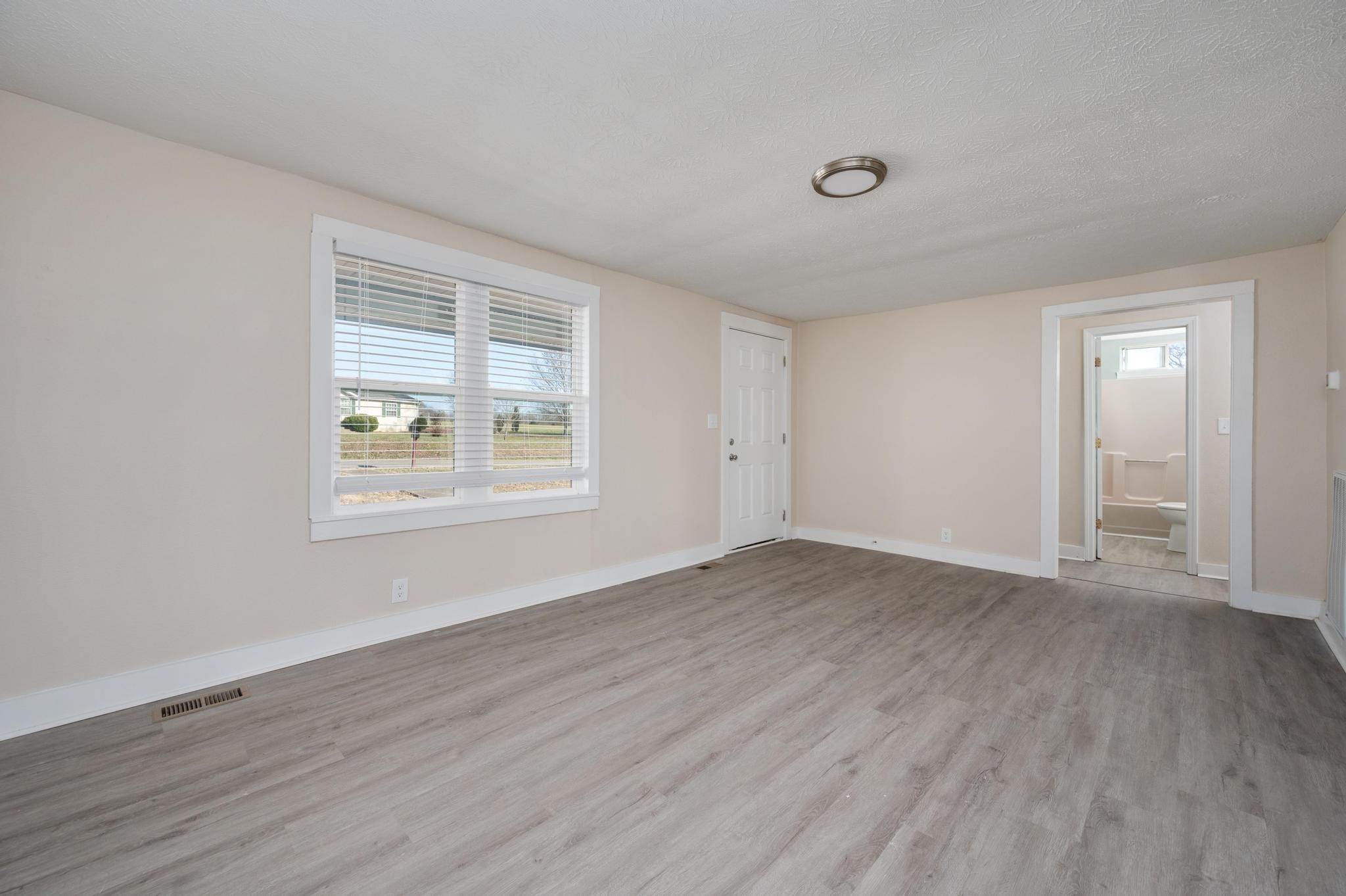 621 Halltown Road Portland, TN 37148 - Photo 3 of 23 a view of an empty room with wooden floor and a window