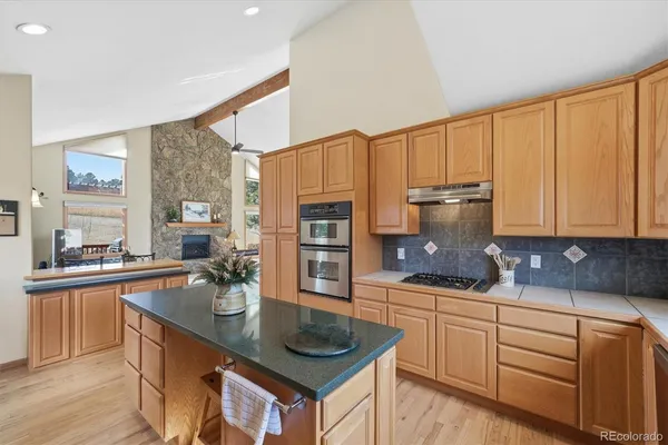 a kitchen with stainless steel appliances a sink a stove and cabinets